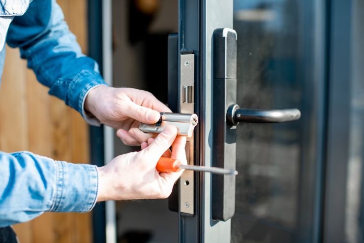 uomo cambia serratura porta di casa