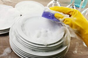 Lavare piatti con spugna e guanti