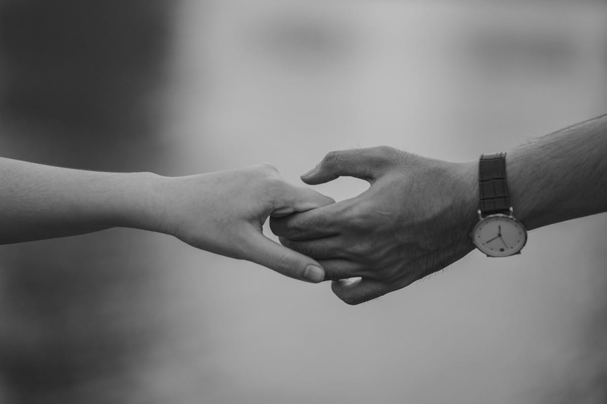 Ragazzo e ragazza che si toccano l'uno la mano dell'altra