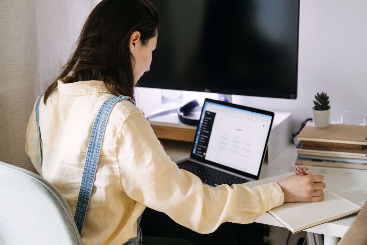 Donna seduta alla scrivania di fronte ad un computer