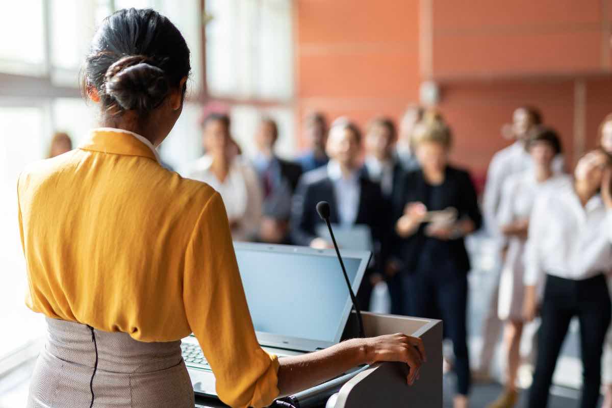 persone in una stanza e una di spalle in primo piano